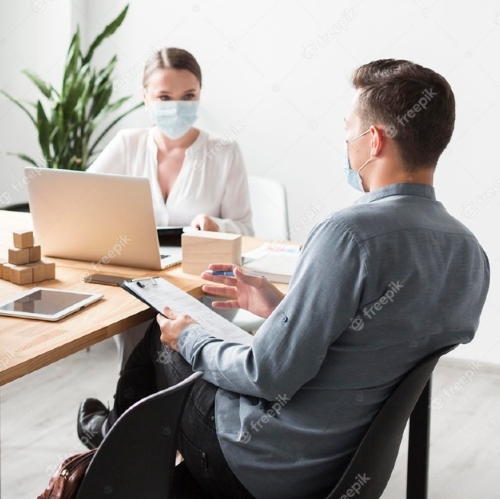 An image of 2 employee working with a mask on their face